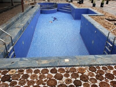 Piscine avec spa circulaire intégré et plage décorative en rondins de bois