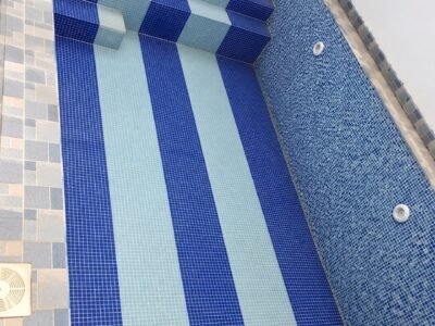 Piscine en mosaïque bleue à bandes avec escalier intégré