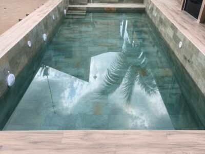 Piscine en mosaïque turquoise avec margelles en grès cérame effet bois
