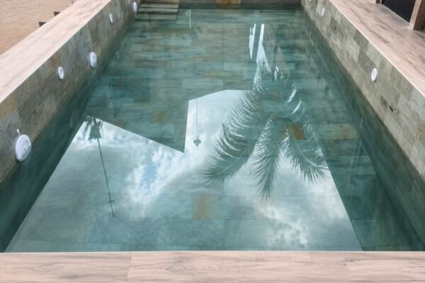Piscine en mosaïque turquoise avec margelles en grès cérame effet bois
