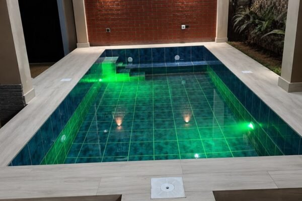 Piscine couverte avec éclairage LED vert et margelles effet bois